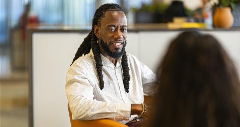 Man sitting talking to a coworker